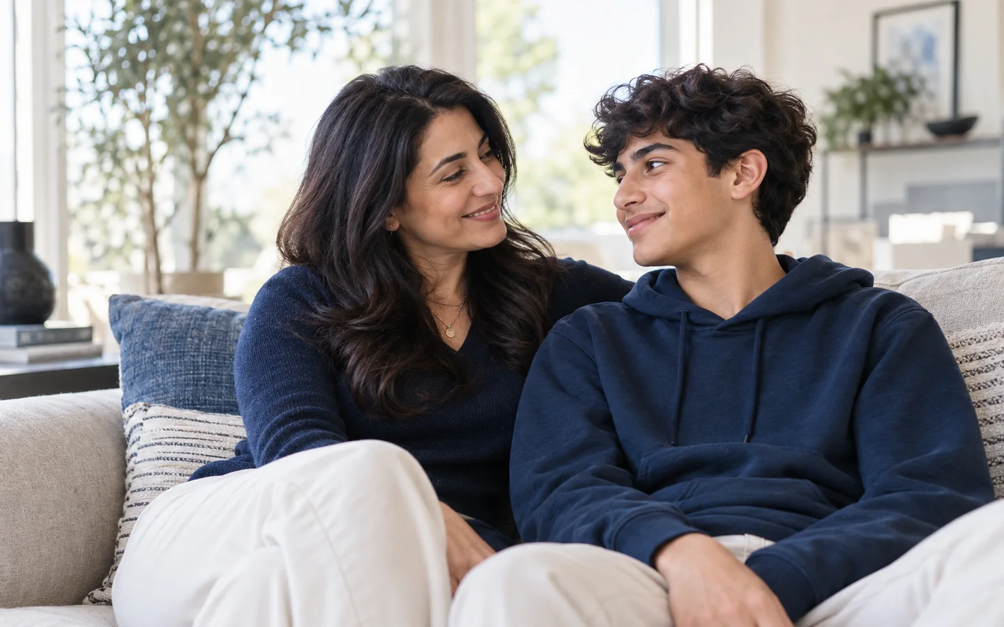 Mother and son smiling together at home