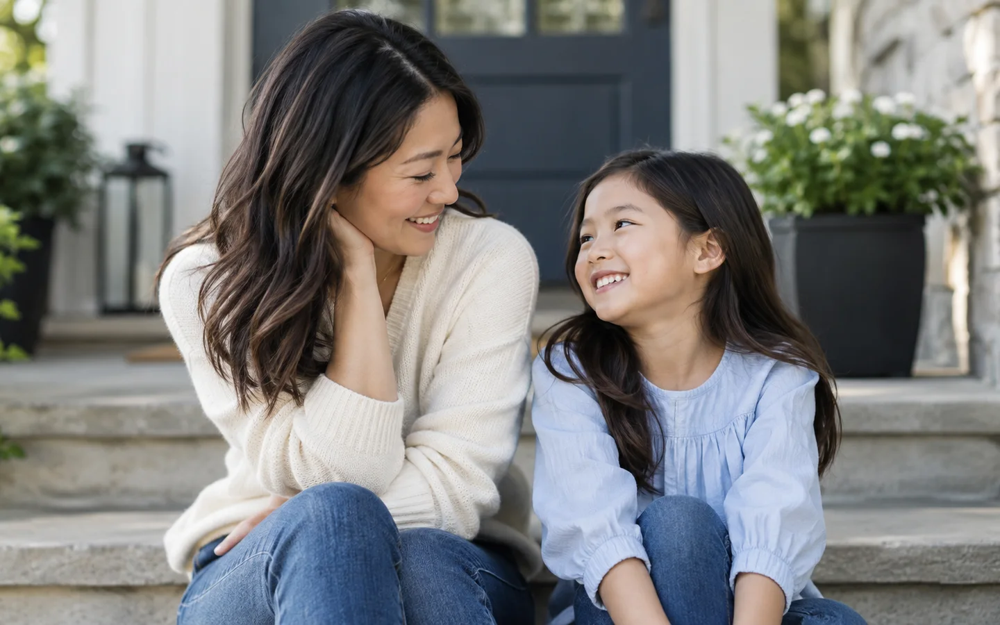 Mother and daughter smiling together on outdoor steps