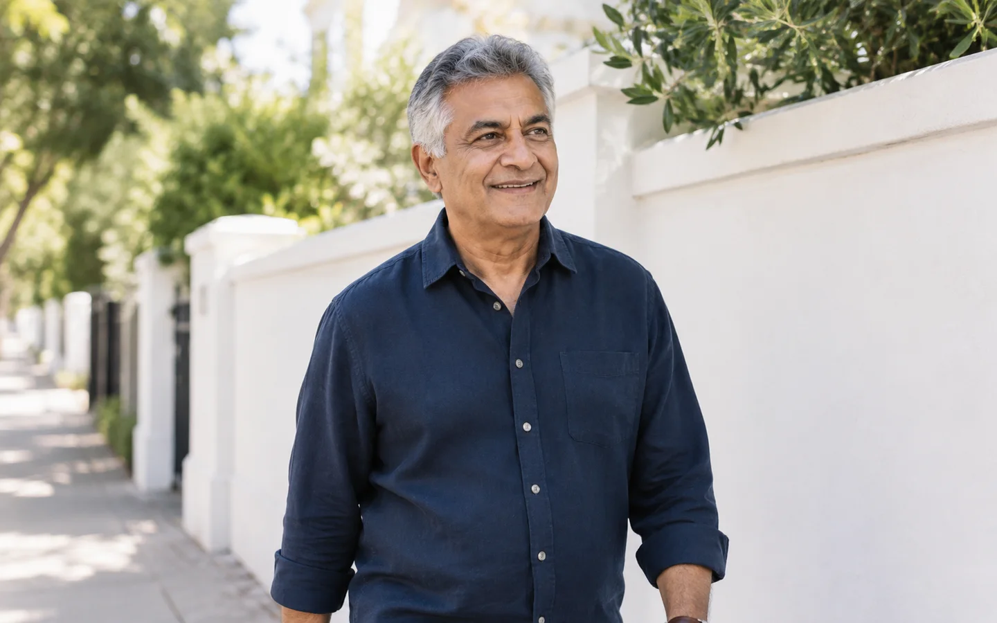 Mature man smiling near a residential walkway